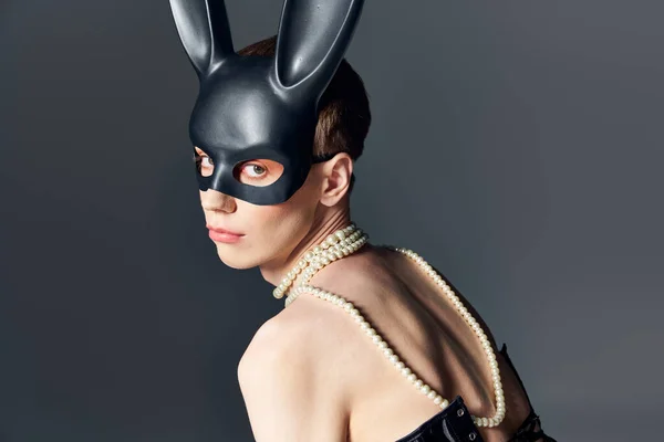 Удивительный человек в корсете и маске кролика позирует на сером, лацкане, кружевном ожерелье, элегантной моде — стоковое фото