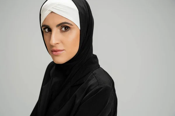Профессиональный снимок мусульманки-предпринимательницы в черной куртке на сером — стоковое фото