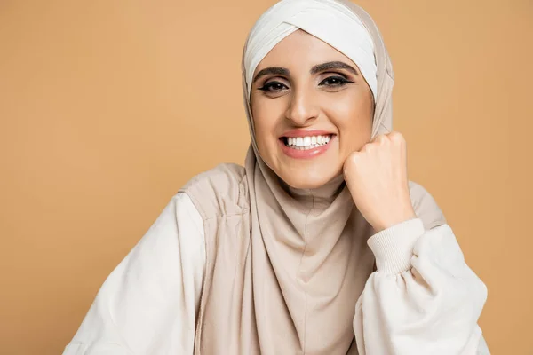Glückliche muslimische Frau im Hijab und weißem Sweatshirt, die auf beigem, modernem Lebensstil in die Kamera lächelt — Stockfoto