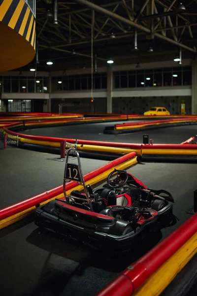Progettazione di auto da corsa all'interno del circuito di kart indoor, veicolo da corsa rosso con numero dodici — Foto stock