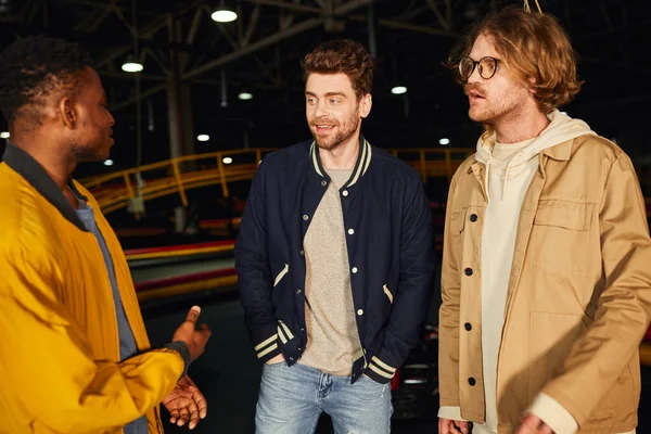 Happy interracial friends having conversation inside of indoor track, go-cart concept, hobby — Stock Photo