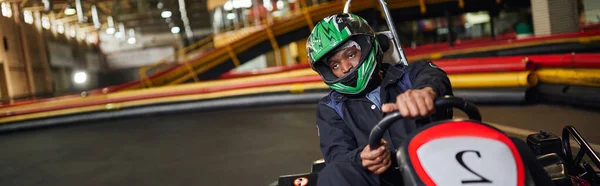 Pilote afro-américain en casque sur circuit, concept de karting motorsport, bannière horizontale — Photo de stock