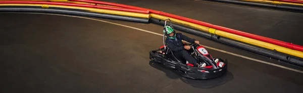 Homme afro-américain en go-kart sur circuit, course à l'intérieur de la piste de karting intérieur, bannière — Photo de stock