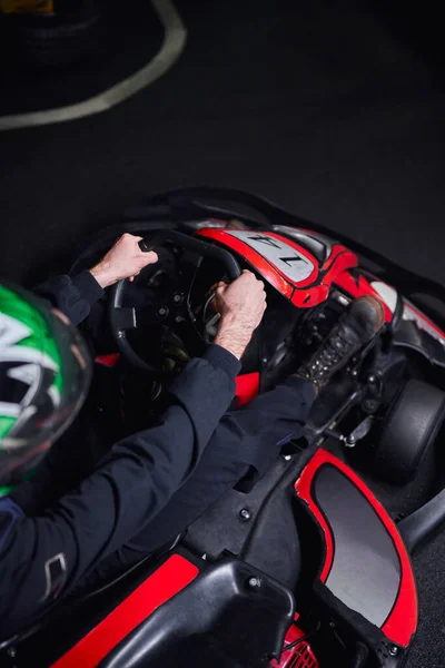 Vue de dessus de l'homme dans le casque et la conduite de vêtements de sport aller kart sur le circuit intérieur, concept d'adrénaline — Photo de stock