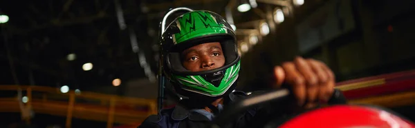 Afro-americano go cart racer em capacete dirigindo no circuito indoor, speed racing challenge, banner — Fotografia de Stock