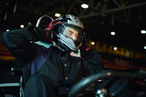 Go kart driver decolando capacete depois de dirigir no circuito, unidade de velocidade e conceito de automobilismo — Fotografia de Stock