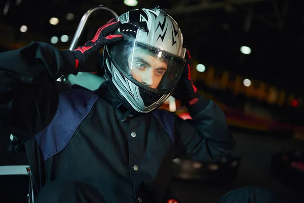 Go kart driver decolando capacete depois de corrida no circuito, unidade de velocidade e conceito de automobilismo — Fotografia de Stock