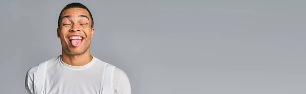 Uomo afroamericano in t-shirt alla moda, con gli occhi chiusi, sporgente sul grigio, banner, spazio copia — Foto stock