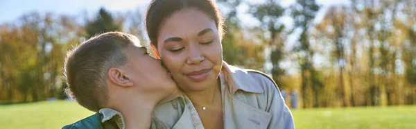 Связывание и любовь, сын целуя щеку матери, счастливый африканский американец женщина и мальчик, падение, баннер — стоковое фото