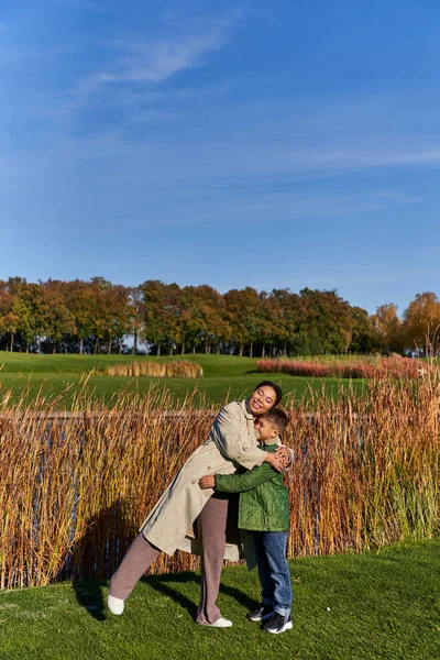 Bonding, glücklich afrikanisch-amerikanische Mutter umarmt Sohn, Oberbekleidung, Frau und Junge, Herbst, Herbstsaison — Stockfoto
