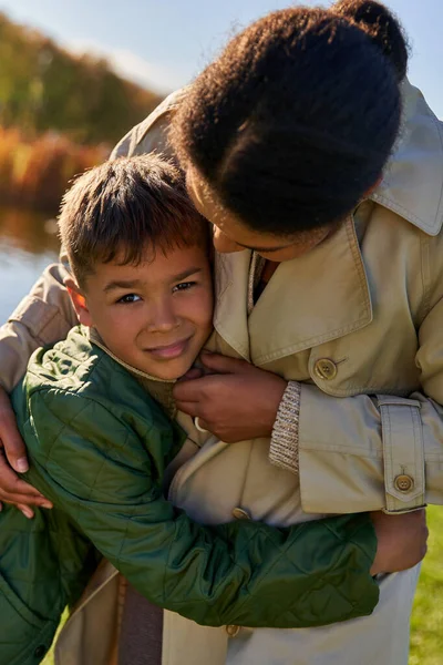 Женщина успокаивает расстроенный мальчик, африканская американская мать и ребенок, семейные узы, осенняя природа — стоковое фото