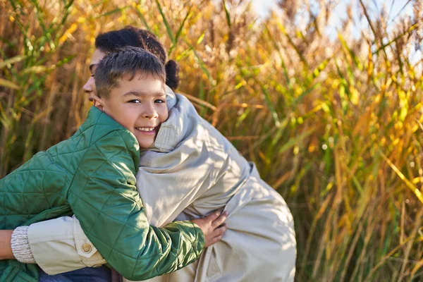 Happiness, love, african american boy in autumnal clothes hugging mother, autumn, fall season, smile — Stock Photo