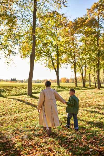 Happy memories, mother and son walking in park, autumn leaves, fall season, african american family — Stock Photo