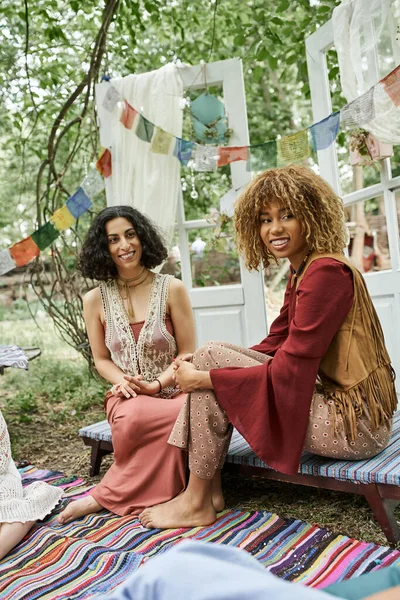 Positive and stylish multiethnic women spending time together outdoors in retreat center — Stock Photo