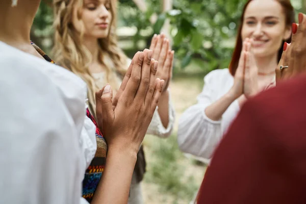 Multiethnic women in boho clothes praying and meditating together in retreat center — Stock Photo