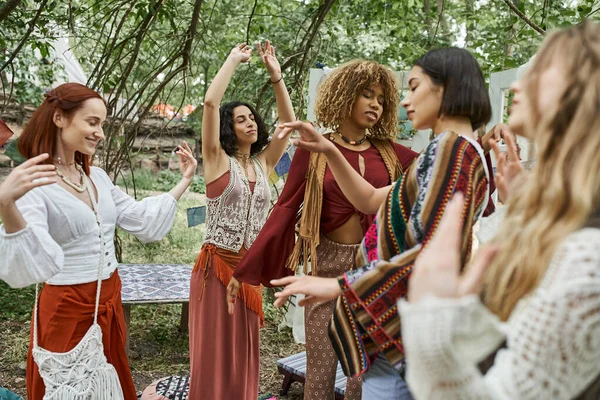 Amigos multiétnicos elegantes com olhos fechados dançando ao ar livre no centro de retiro moderno — Fotografia de Stock