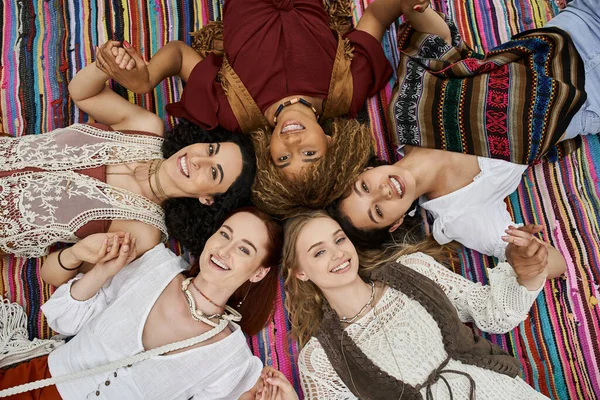 Vista superior de alegres mujeres interracial mirando a la cámara en la manta en el centro de retiro — Stock Photo