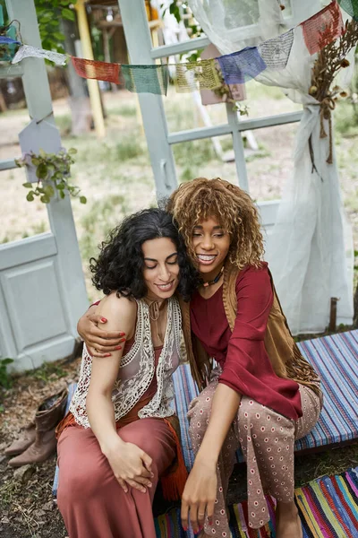 Smiling african american woman hugging multicultural friend outdoors in retreat center — Stock Photo
