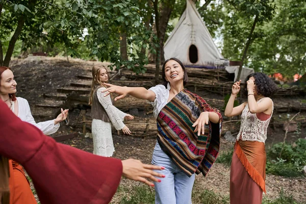 Smiling woman dancing together with multiethnic friends in summer in retreat center — Stock Photo
