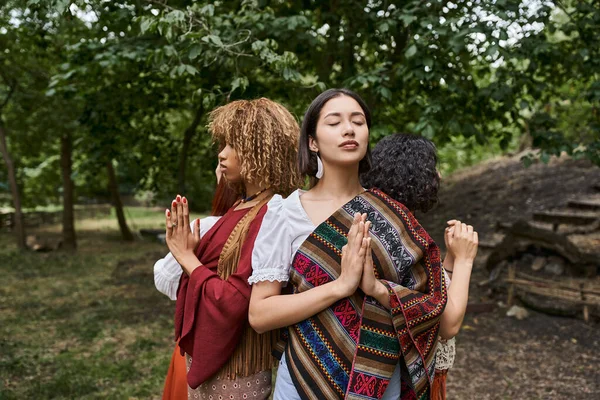 Young interracial women doing praying hands gesture while standing in outdoor retreat center — Stock Photo