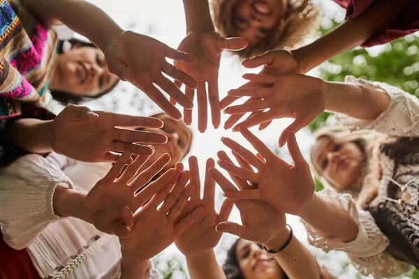 Blick von unten auf verschwommene interrassische Frauen, die im Rückzugszentrum mit den Händen in die Kamera winken — Stockfoto