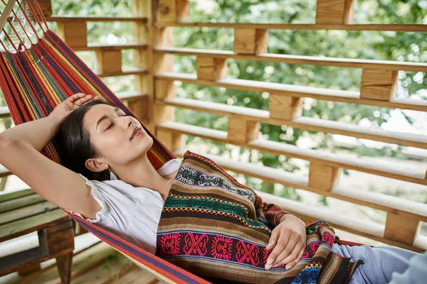 Mujer atractiva joven que duerme en la hamaca, relajación, disfrute, concepto del retiro de las mujeres - foto de stock