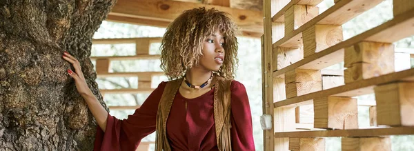 Dreamy and stylish african american woman looking away on patio of retreat center — Stock Photo