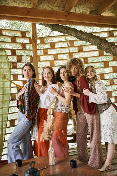 Multiethnische Frauen in stylischer Boho-Kleidung stehen und blicken in die Kamera im Rückzugszentrum — Stockfoto