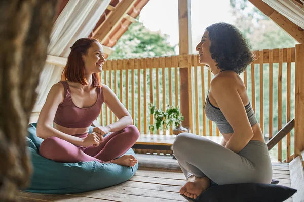 Frauen Erholungskonzept, fröhliche multiethnische Freundinnen meditieren im Patio in Lotus-Pose — Stockfoto