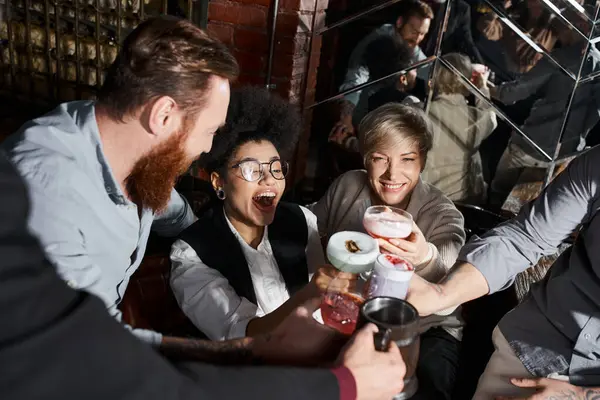 Excité femme afro-américaine cliquetis lunettes avec des collègues multiethniques dans le bar après le travail — Photo de stock