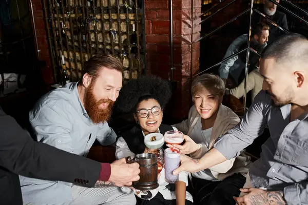 Joyous multiethnic colleagues toasting with alcohol drinks in cocktail bar, leisure and fun — Stock Photo