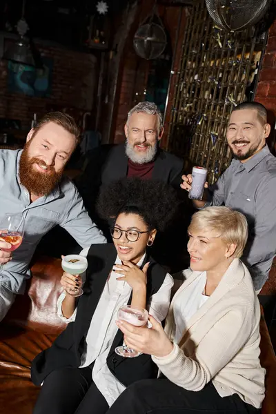Donna afro-americana felicissima che ride vicino a colleghi multiculturali con bevande nel cocktail bar — Foto stock