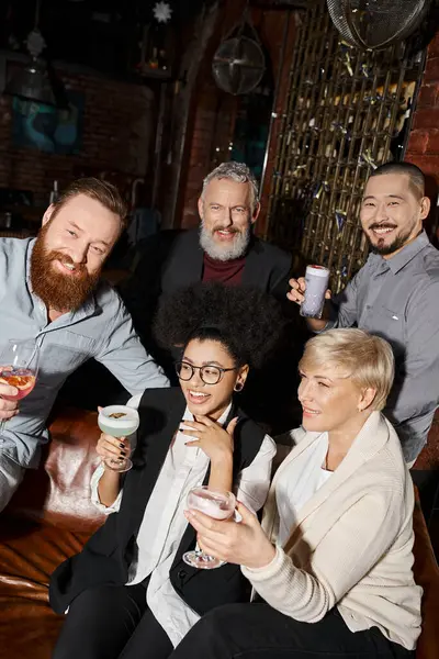 Overjoyed african american woman laughing near multicultural colleagues with drinks in cocktail bar — Stock Photo