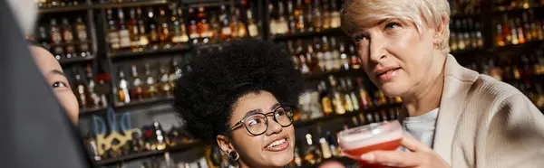 Mulher de meia-idade conversando com colegas perto sorrindo mulher afro-americana no bar, banner — Fotografia de Stock