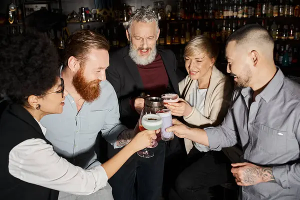 Equipe de negócios multiétnica alegre e bem sucedida que clica copos ao passar o tempo no bar de coquetéis — Fotografia de Stock