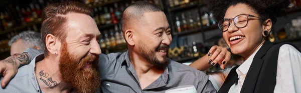 Щасливі і успішні багатоетнічні колеги сміються під час після робочої вечірки в барі, банер — стокове фото