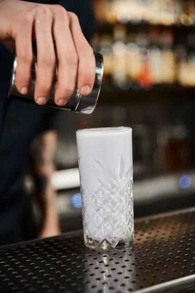 Abgeschnittene Ansicht des Barkeepers, der Zimt im Glas mit Milchpunsch hinzufügt, Cocktailkunst im Bar-Ambiente — Stockfoto