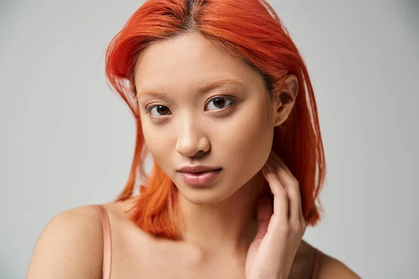 Porträt der schönen jungen asiatischen Frau, die auf grauem Hintergrund isoliert in die Kamera blickt, natürliches Make-up — Stockfoto