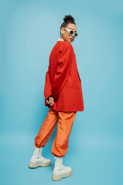 Persönlicher Stil, junges afrikanisch-amerikanisches Model in lebendigem Outfit posiert auf blauem Hintergrund — Stockfoto
