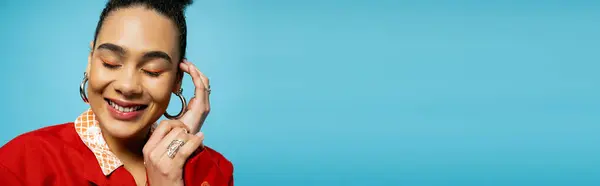 Portrait de heureux modèle afro-américain en accessoires argentés souriant sur fond bleu, bannière — Photo de stock
