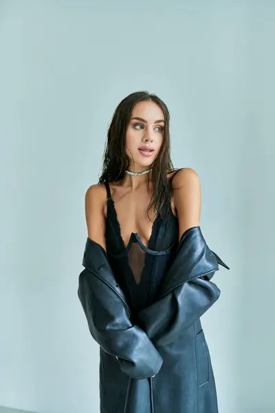 Seducente donna con capelli castani in posa in biancheria intima nera pizzo corsetto e cappotto di pelle — Foto stock