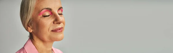 Close-up retrato de senhora madura com maquiagem natural sorrindo com os olhos fechados em cinza, banner — Fotografia de Stock