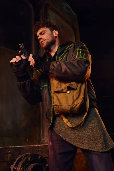 Hombre con bolsa de lona pistola de control en peligro ambiente de metro abandonado, personaje del juego - foto de stock