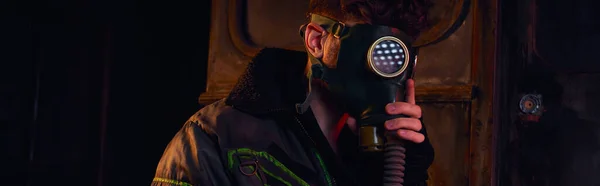 Людина в газовій масці і зношена куртка в темному підземному тунелі, концепція після стихійних лих, банер — стокове фото