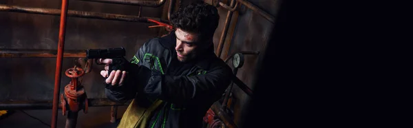 Недбалий чоловік в одязі, прицілюється з пістолетом у підземці після стихійних лих, високий кут зору, банер — стокове фото