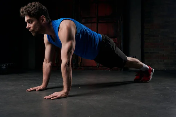 Full length of strong man in sportswear training in plank pose in darkness of night street — Stock Photo