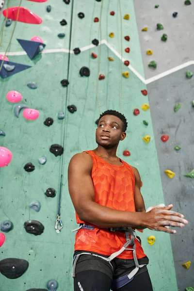 Вертикальный кадр спортивного африканского американца с альпийской аркадой с помощью гимнастического мелом и отводя взгляд — стоковое фото