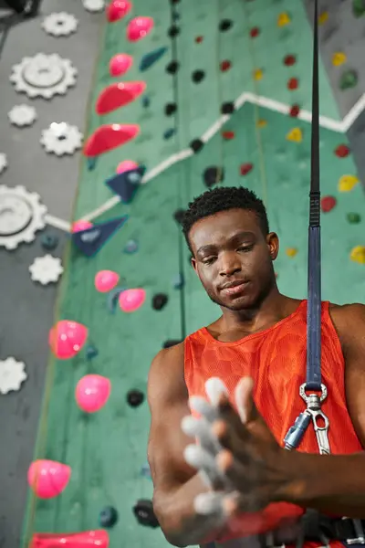 Schöner junger afrikanisch-amerikanischer Mann, der Turnkreide benutzt, bevor er die Wand hochklettert, Boulderkonzept — Stockfoto