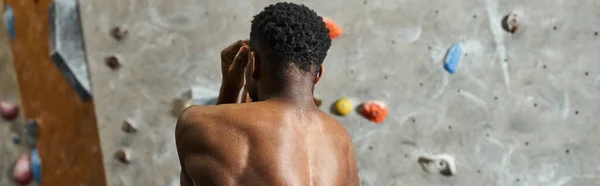 Homme afro-américain athlétique avec sa chemise de muscles fléchissants près du mur de blocs, bannière — Photo de stock