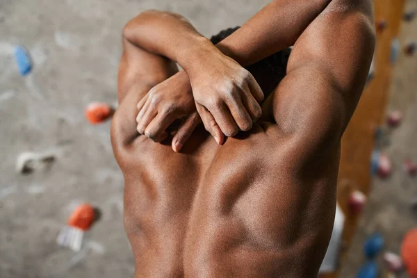 Athlétique torse nu homme afro-américain fléchissant ses muscles avec les mains croisées derrière la tête — Photo de stock